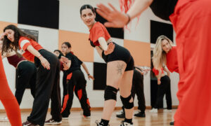 Adult dancers in coordinated group choreography during dance class
