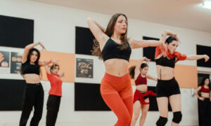 Confident adult dancer leading a group performance in a studio