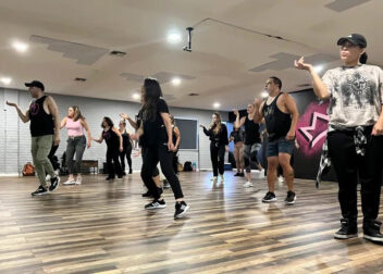 Adult hip hop dance class in session at the Royal Peacock Studio in Oakland Park, Florida, with a group of diverse dancers following choreography in a modern studio setting